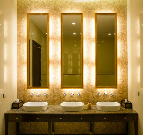 View Modern style interior design of a bathroom. Install bulb behind a mirror glass decorative gold picture frame and faucet and wash bowl on table